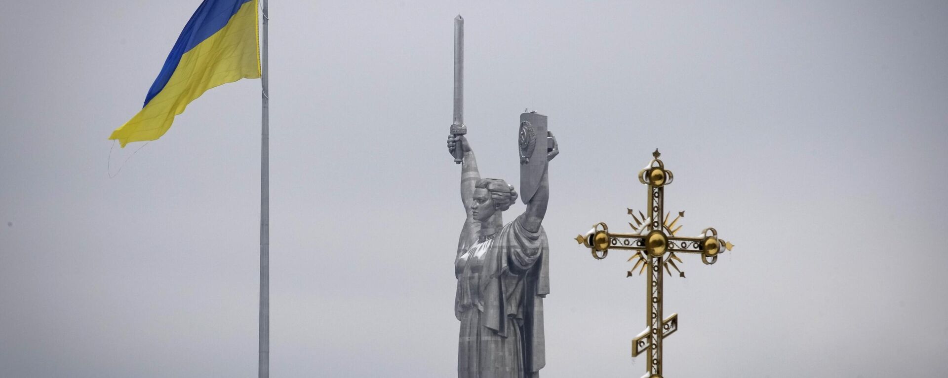 Bandeira ucraniana ao lado da cruz do monastério Pecherskaya Lavra e o Monumento da Terra-Mãe em Kiev, Ucrânia, 22 de novembro de 2022 - Sputnik Brasil, 1920, 20.01.2023