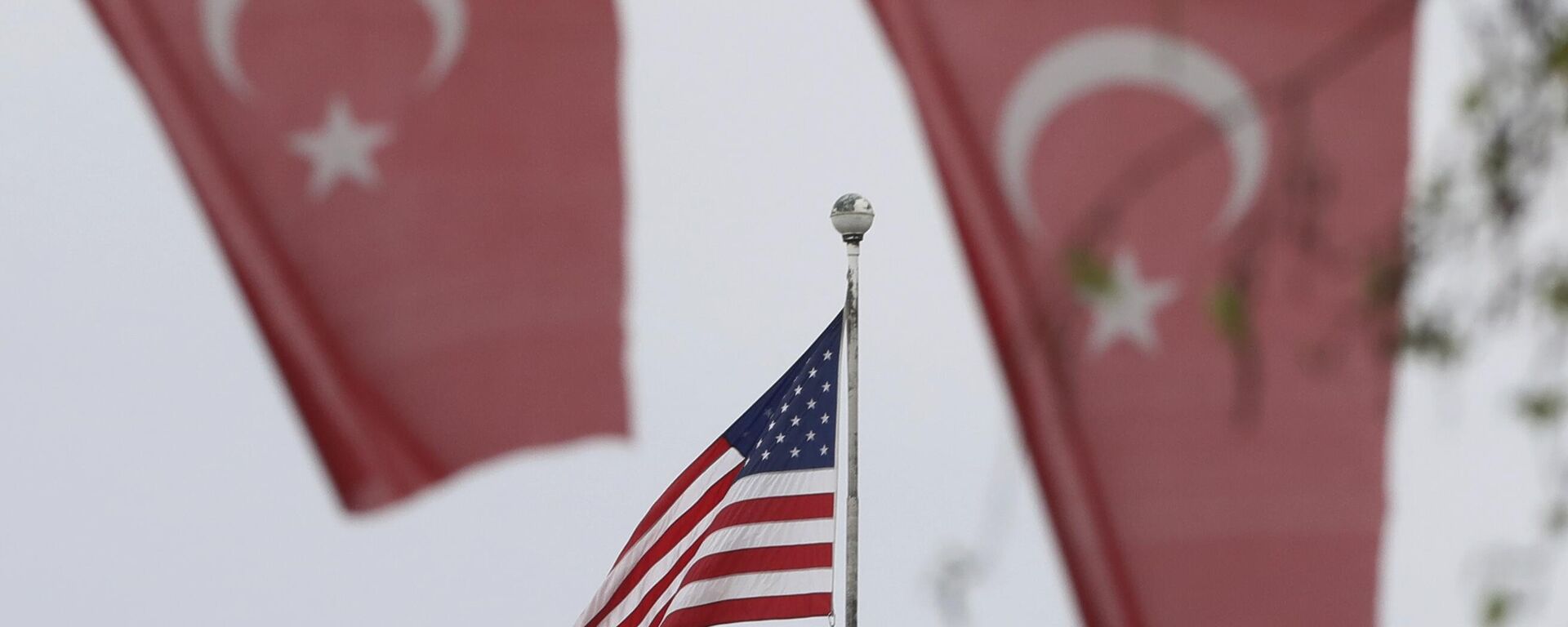 Bandeiras da Turquia no primeiro plano, e dos EUA no segundo plano, fora da embaixada dos EUA em Ancara, Turquia, 25 de abril de 2021 - Sputnik Brasil, 1920, 08.03.2023