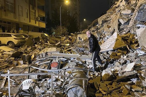 Homem caminha entre destroços de edifícios em Diyarbakir, sudeste da Turquia. - Sputnik Brasil