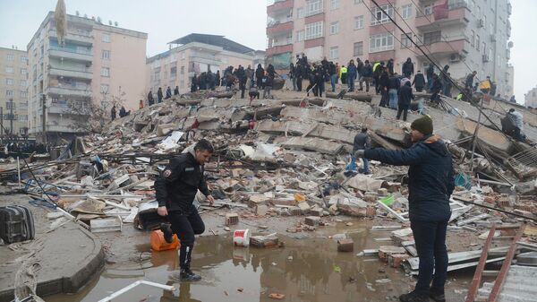Pessoas buscam sobreviventes debaixo dos escombros após a queda de prédio causado por terremoto na Turquia e na Síria, no sudeste da Turquia, 6 de fevereiro de 2023 - Sputnik Brasil