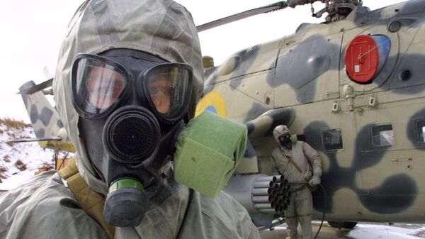 Soldado ucraniano usa traje de proteção e máscara de gás durante exercícios das forças ucranianas de armas antiquímicas em Kalinov, 620 quilômetros a oeste de Kiev, Ucrânia, 14 de março de 2003 - Sputnik Brasil