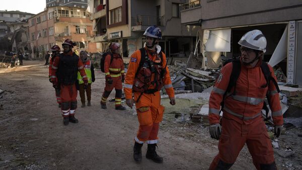 Membros da equipe de resgate britânica exploram os prédios destruídos em Antakya, sul da Turquia, 9 de fevereiro de 2023 - Sputnik Brasil