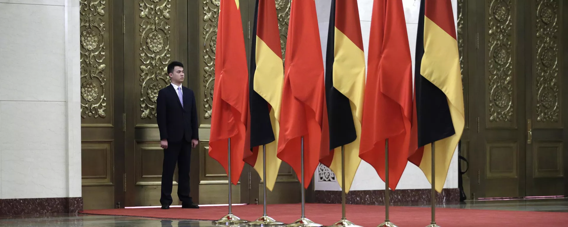 Guarda junto de bandeiras da China e da Alemanha durante encontro entre Xi Jinping, presidente chinês, e Angela Merkel, então chanceler alemã, no Grande Salão do Povo, em Pequim. China, 24 de maio de 2018 - Sputnik Brasil, 1920, 17.05.2024