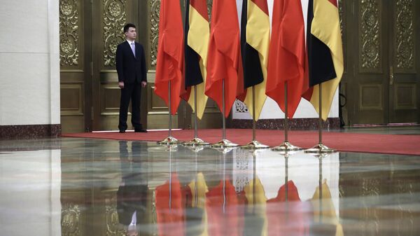 Guarda junto de bandeiras da China e da Alemanha durante encontro entre Xi Jinping, presidente chinês, e Angela Merkel, chanceler alemã (ambos fora da foto), no Grande Salão do Povo, Pequim, China, 24 de maio de 2018 - Sputnik Brasil