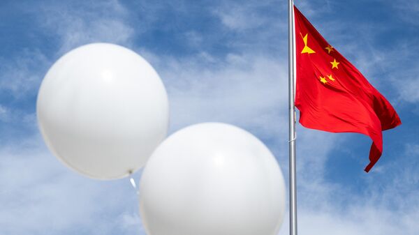 Dois balões brancos flutuam perto da bandeira chinesa enquanto o ativista Rev. Patrick Mahoney protesta contra o governo chinês sobre o suposto balão de vigilância chinês que foi abatido sobre os EUA na semana passada, durante uma manifestação do lado de fora da Embaixada da China em Washington, DC, 15 de fevereiro de 2023 - Sputnik Brasil