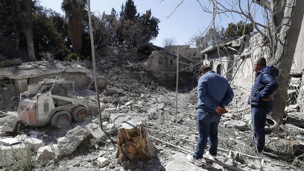 Pessoas inspecionam os danos causados após um ataque aéreo israelense na capital Damasco. Síria, 19 de fevereiro de 2023 - Sputnik Brasil