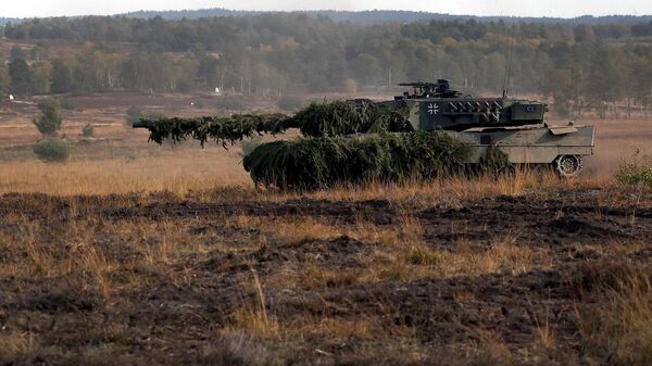 Um tanque de batalha Leopard 2 das Forças Armadas alemãs (Bundeswehr) dirige durante uma visita do chanceler alemão à tropa do Bundeswehr alemão durante um exercício de treinamento no campo militar em Ostenholz, norte da Alemanha, 17 de outubro de 2022 - Sputnik Brasil
