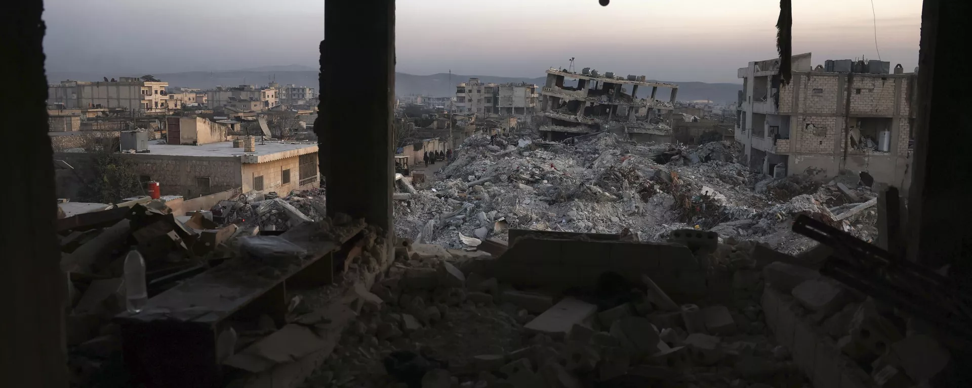 Edifícios desmoronados são vistos pelas janelas de uma casa danificada após um terremoto devastador na cidade de Jinderis, província de Aleppo, Síria, 9 de fevereiro de 2023 - Sputnik Brasil, 1920, 02.06.2024
