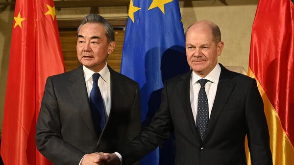 Olaf Scholz, chanceler alemão, à direita, cumprimenta o diretor da Comissão Central de Relações Exteriores da China, Wang Yi, na Conferência de Segurança de Munique, Alemanha, em 17 de fevereiro de 2023. - Sputnik Brasil