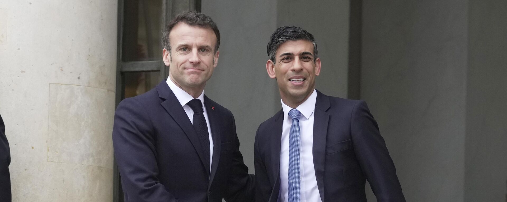 Primeiro-ministro britânico, Rishi Sunak, à direita, e presidente francês, Emmanuel Macron, dão aperto de mãos durante reunião no Palácio do Eliseu em Paris, 10 de março de 2023 - Sputnik Brasil, 1920, 10.03.2023
