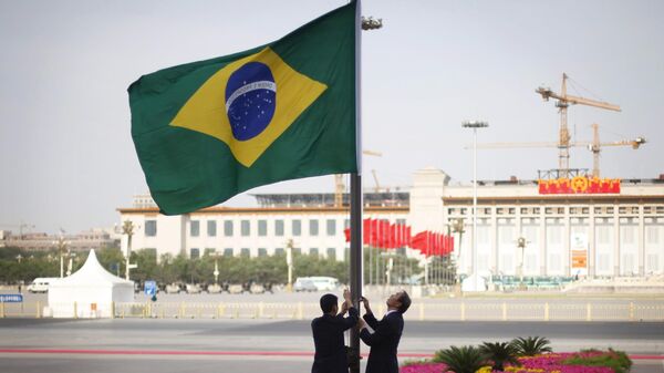Uma bandeira brasileira é hasteada antes da cerimônia de boas-vindas do presidente brasileiro Luiz Inácio Lula da Silva no Grande Salão do Povo em Pequim - Sputnik Brasil