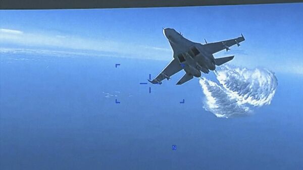 Esta foto tirada de um vídeo lançado na quinta-feira, 16 de março de 2023, mostra um caça Su-27 russo se aproximando da parte de trás do drone MQ-9 e começando a liberar combustível ao passar, sobre o mar Negro, disse o Pentágono. - Sputnik Brasil