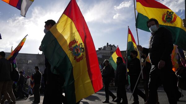 Manifestantes seguram bandeiras bolivianas enquanto marcham exigindo o aprisionamento para o líder da oposição e governador da região de Santa Cruz Luis Fernando Camacho em La Paz. Bolívia, 12 de janeiro de 2023 - Sputnik Brasil