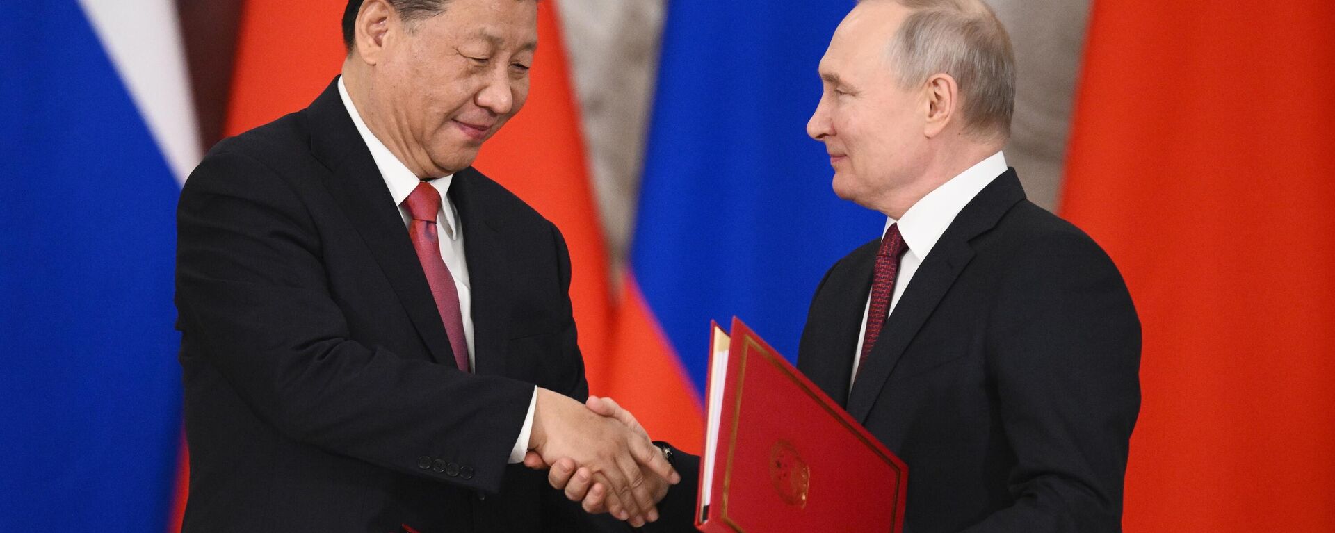 O líder chinês Xi Jinping e o presidente russo Vladimir Putin apertam as mãos após a assinatura de uma declaração conjunta sobre o aprofundamento da parceria abrangente e cooperação estratégica e sobre o plano de desenvolvimento de áreas-chave da cooperação econômica até 2023 no kremlin de moscou, Rússia - Sputnik Brasil, 1920, 22.03.2023