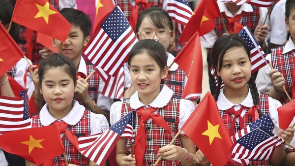 Estudantes vietnamitas seguram bandeiras do Vietnã e dos EUA enquanto esperam pelo presidente norte-americano Barack Obama no Palácio Presidencial, Hanói, Vietnã, 23 de maio de 2016 - Sputnik Brasil