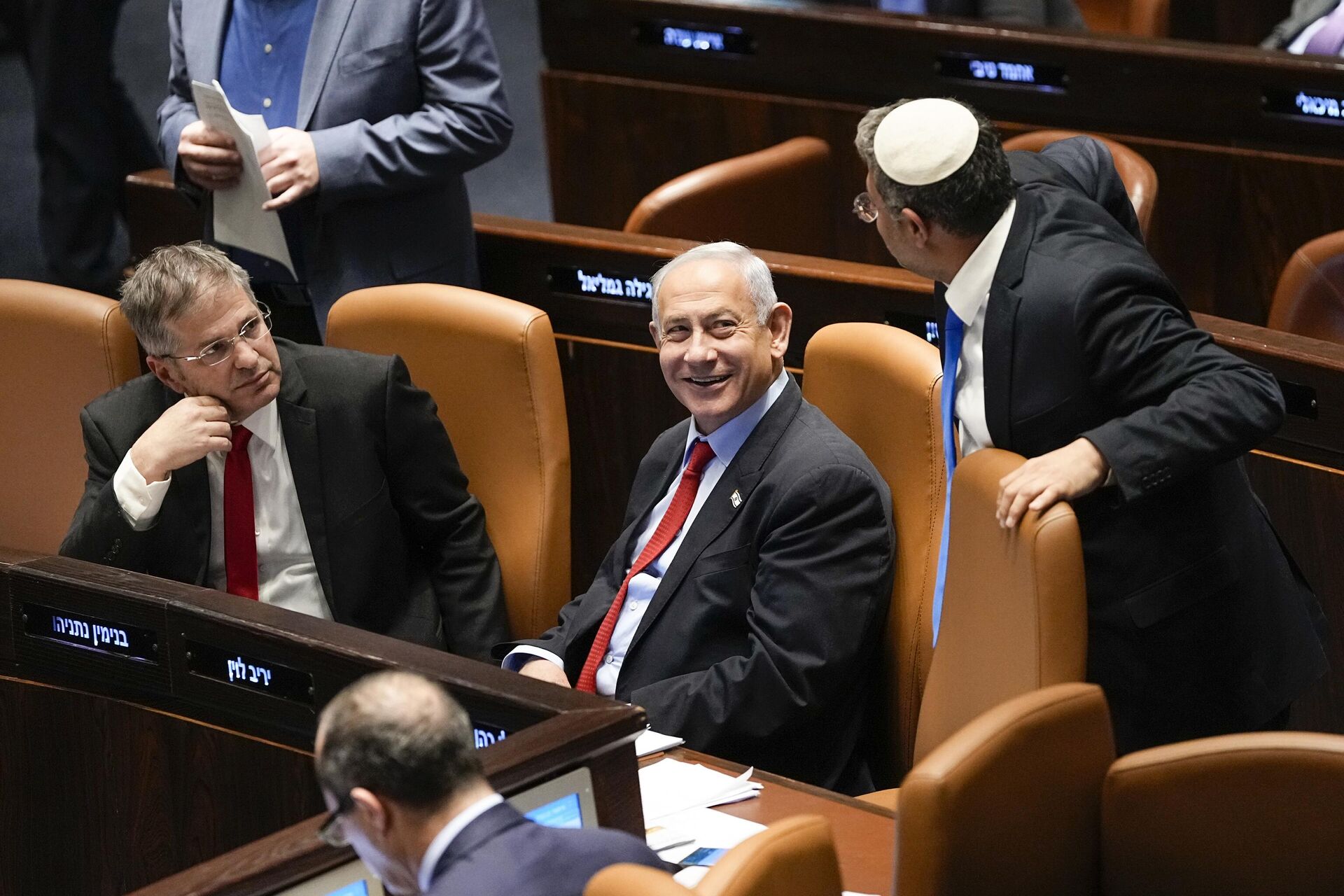 O primeiro-ministro israelense Benjamin Netanyahu, ao centro, sorri enquanto Itamar Ben-Gvir, ministro da Segurança Nacional, e o ministro da Educação, Yoav Kisch, à esquerda, olham para o parlamento de Israel, o Knesset, em Jerusalém, 22 de fevereiro de 2023 - Sputnik Brasil, 1920, 26.04.2024