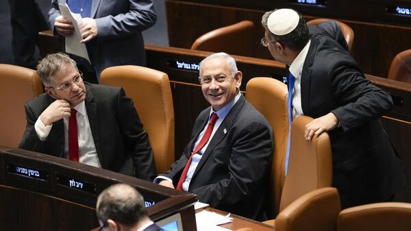 O primeiro-ministro israelense Benjamin Netanyahu, ao centro, sorri enquanto Itamar Ben-Gvir, ministro da Segurança Nacional, e o ministro da Educação, Yoav Kisch, à esquerda, olham para o parlamento de Israel, o Knesset, em Jerusalém, 22 de fevereiro de 2023 - Sputnik Brasil