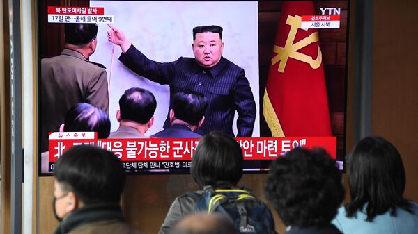 Pessoas assistem a uma tela de televisão mostrando um noticiário com imagens de arquivo do líder norte-coreano Kim Jong Un, em uma estação ferroviária em Seul, em 13 de abril de 2023 - Sputnik Brasil