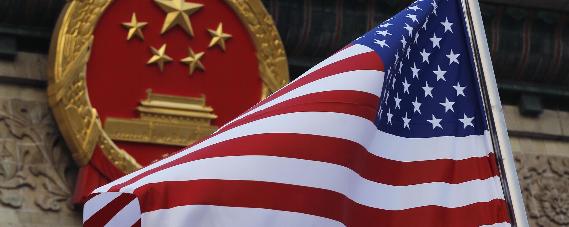Uma bandeira americana é hasteada ao lado do emblema nacional chinês durante uma cerimônia de boas-vindas à visita do presidente dos EUA Donald Trump fora do Grande Salão do Povo em Pequim, 9 de novembro de 2017. - Sputnik Brasil, 1920, 25.04.2023
