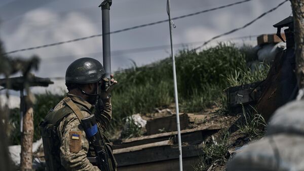 Um soldado ucraniano observa as posições russas por meio de seu periscópio em uma trincheira na linha de frente no vilarejo de Nova York, região de Donetsk, Ucrânia, em 24 de abril de 2023. - Sputnik Brasil