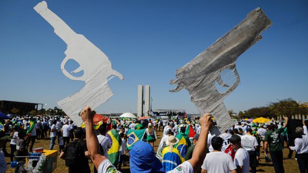 Homem segura dois papelões, cortados em formato de arma, durante manifestação em apoio ao ex-presidente brasileiro Jair Bolsonaro. Brasília, 9 de julho de 2021 - Sputnik Brasil