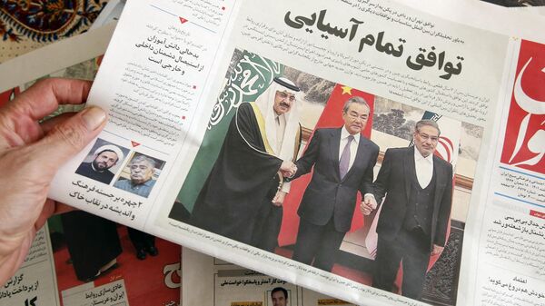 Um homem em Teerã segura um jornal local relatando em sua primeira página o acordo mediado pela China entre o Irã e a Arábia Saudita para restaurar os laços, assinado em Pequim no dia anterior, em 11 de março de 2023 - Sputnik Brasil