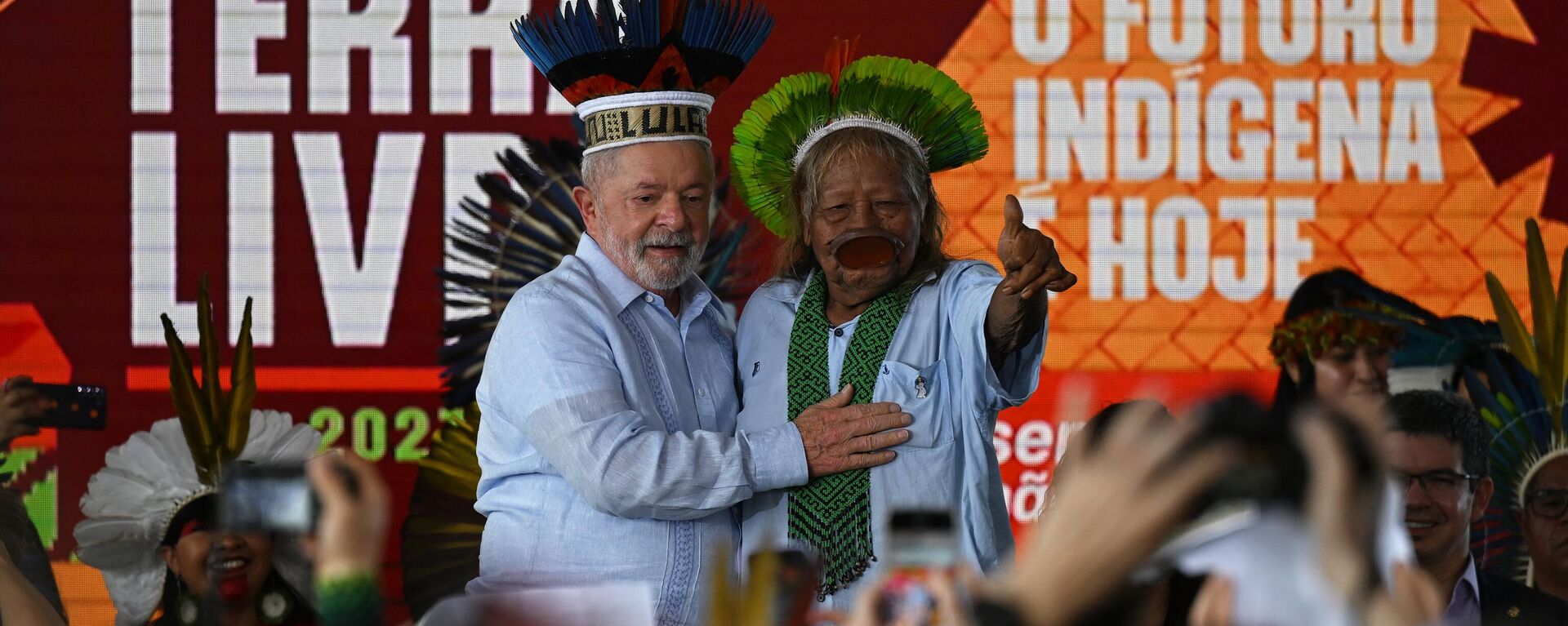 O presidente brasileiro Luiz Inácio Lula da Silva (L) e o líder indígena da tribo Kayapó Cacique Raoni Metuktire (R) gesticulam durante uma visita ao Acampamento Indígena Terra Livre em Brasília em 28 de abril de 2023 - Sputnik Brasil, 1920, 28.04.2023