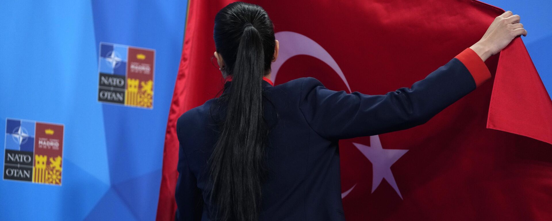 Membro da delegação da Turquia ajusta a bandeira antes de um discurso do presidente turco Recep Tayyip Erdogan durante cúpula da OTAN em Madri, Espanha, 30 de junho de 2022 - Sputnik Brasil, 1920, 13.08.2024