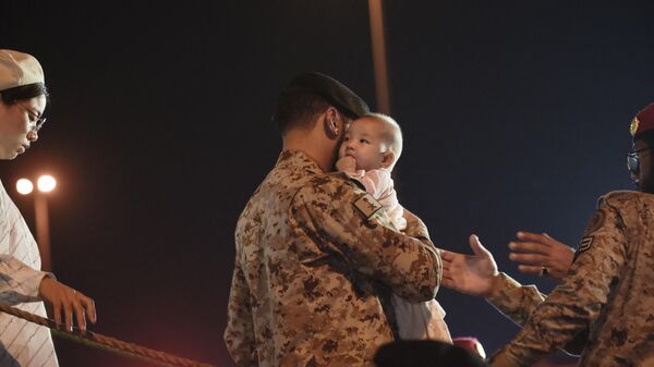 Marinheiros da Marinha saudita ajudam as pessoas evacuadas do Sudão após sua chegada à base naval King Faisal em Jeddah em 26 de abril de 2023. o exército e os paramilitares mataram centenas - Sputnik Brasil