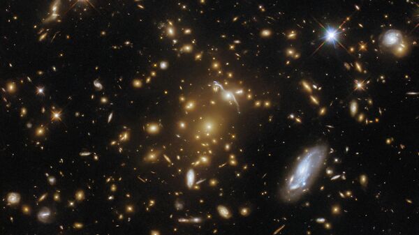 O Telescópio Espacial Hubble registrou uma imagem de um aglomerado de galáxias massivo, o eMACS J1823.1+7822, que fornece informações sobre a distribuição de matéria escura e age como um telescópio natural para observar objetos distantes - Sputnik Brasil