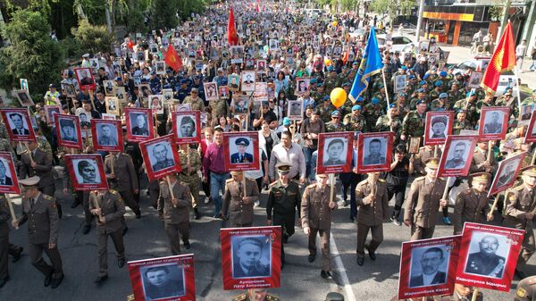 Pessoas carregam retratos de parentes, participantes da Grande Guerra Patriótica, enquanto fazem parte do Regimento Imortal durante as comemorações do Dia da Vitória, marcando o 78º aniversário da vitória sobre a Alemanha nazista na Segunda Guerra Mundial, em Bishkek, Quirguistão - Sputnik Brasil