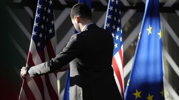 Um trabalhador ajusta as bandeiras dos EUA e da UE antes da chegada do chefe de política externa da União Europeia, Josep Borrell, e do secretário de Estado dos Estados Unidos, Antony Blinken, durante a reunião ministerial do Conselho de Energia UE-EUA no prédio do Conselho Europeu em Bruxelas, 4 de abril de 2023 - Sputnik Brasil