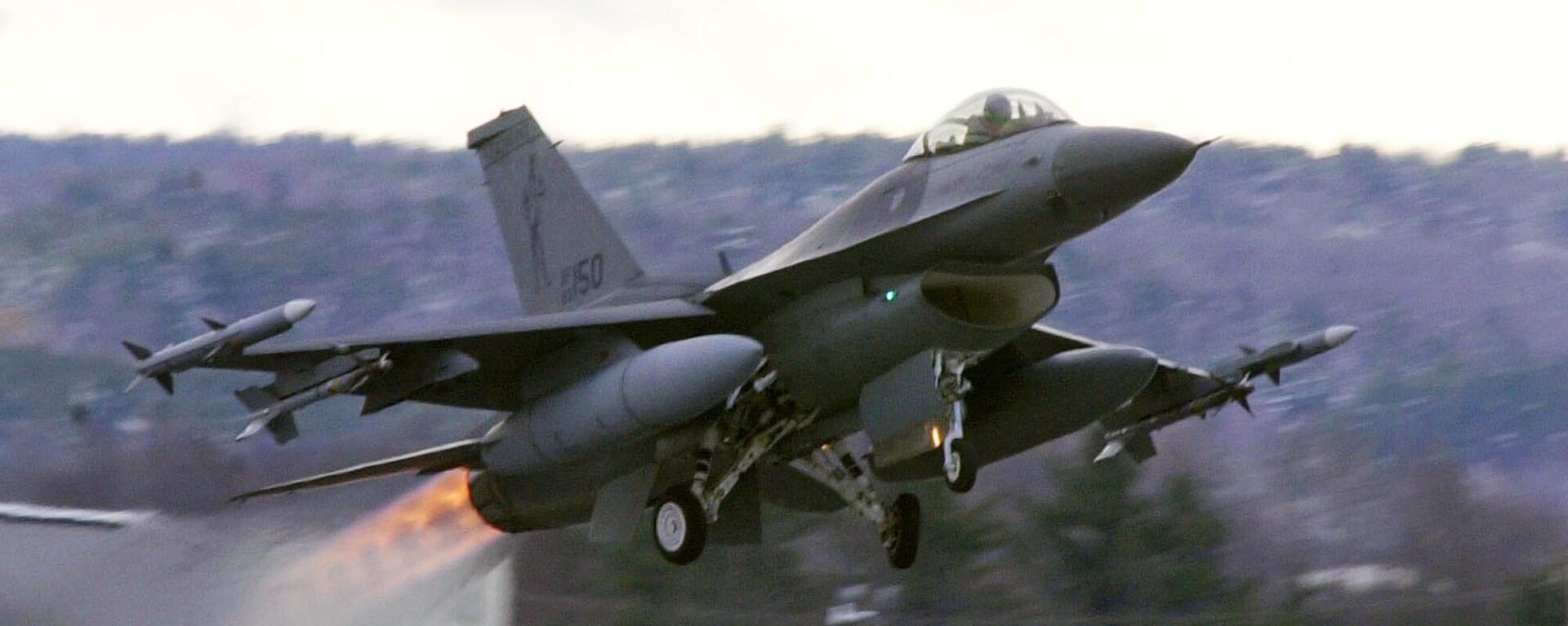 Um caça F-16 decola com pós-combustores carregados de mísseis Sidewinder ativos da base da Guarda Aérea Nacional em South Burlington, Vermont, EUA, dezembro de 2001 - Sputnik Brasil, 1920, 13.07.2023