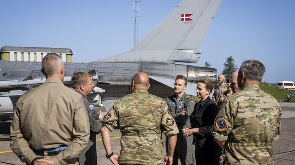 A primeira-ministra dinamarquesa Mette Frederiksen (3R) fala com funcionários da força aérea em frente ao caça F-16 dinamarquês durante uma visita à base aérea da Força Aérea Real Dinamarquesa (RDAF) Fighter Wing Skrydstrup perto de Vojens, em 25 de maio de 2023 - Sputnik Brasil