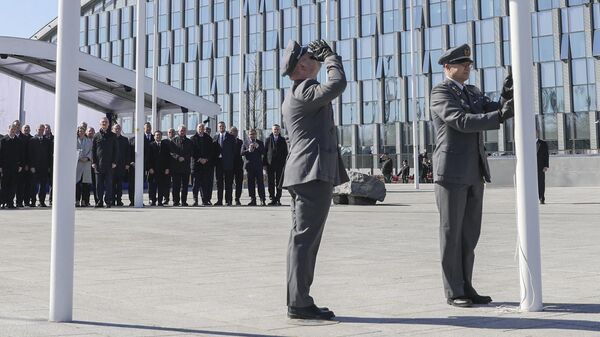 Militares finlandeses instalam bandeira nacional finlandesa na sede da OTAN em Bruxelas, Bélgica, 4 de abril de 2023 - Sputnik Brasil