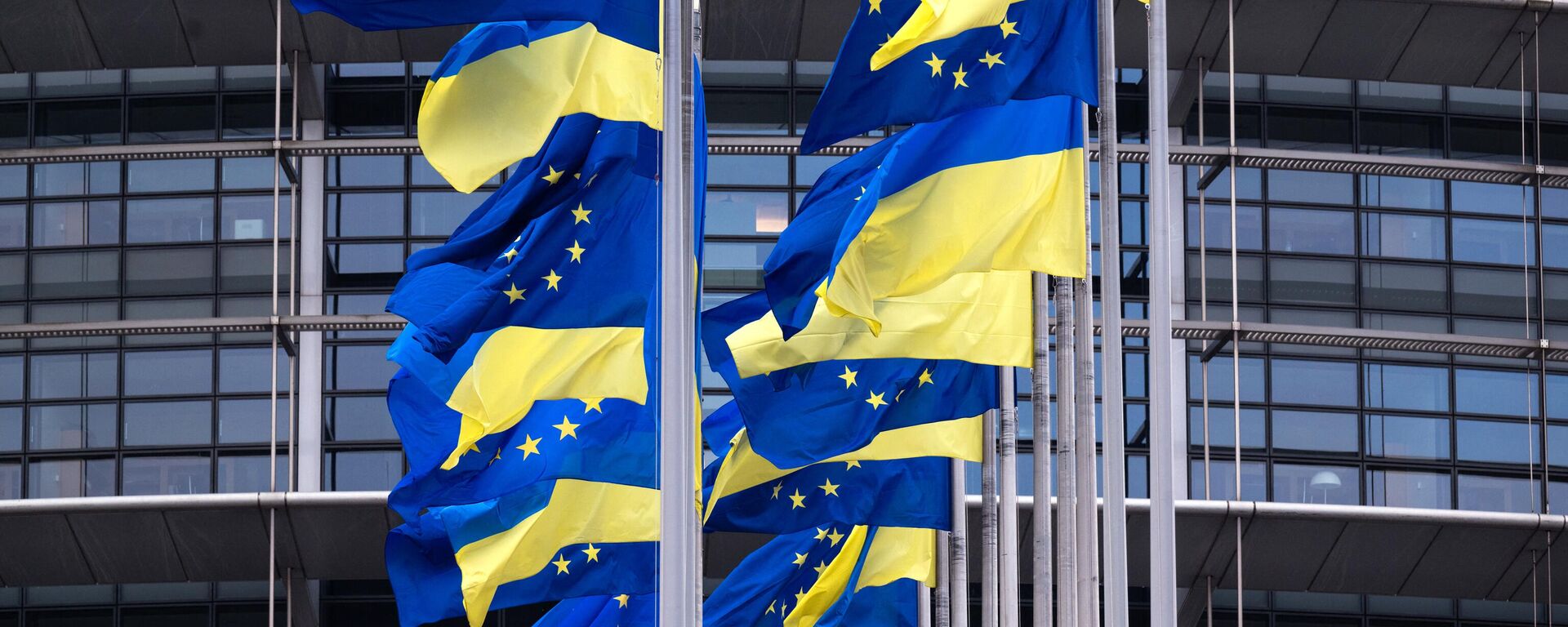 Bandeiras da União Europeia e da Ucrânia tremulando junto do Parlamento Europeu em Estrasburgo, França, 24 de fevereiro de 2023 - Sputnik Brasil, 1920, 24.06.2023