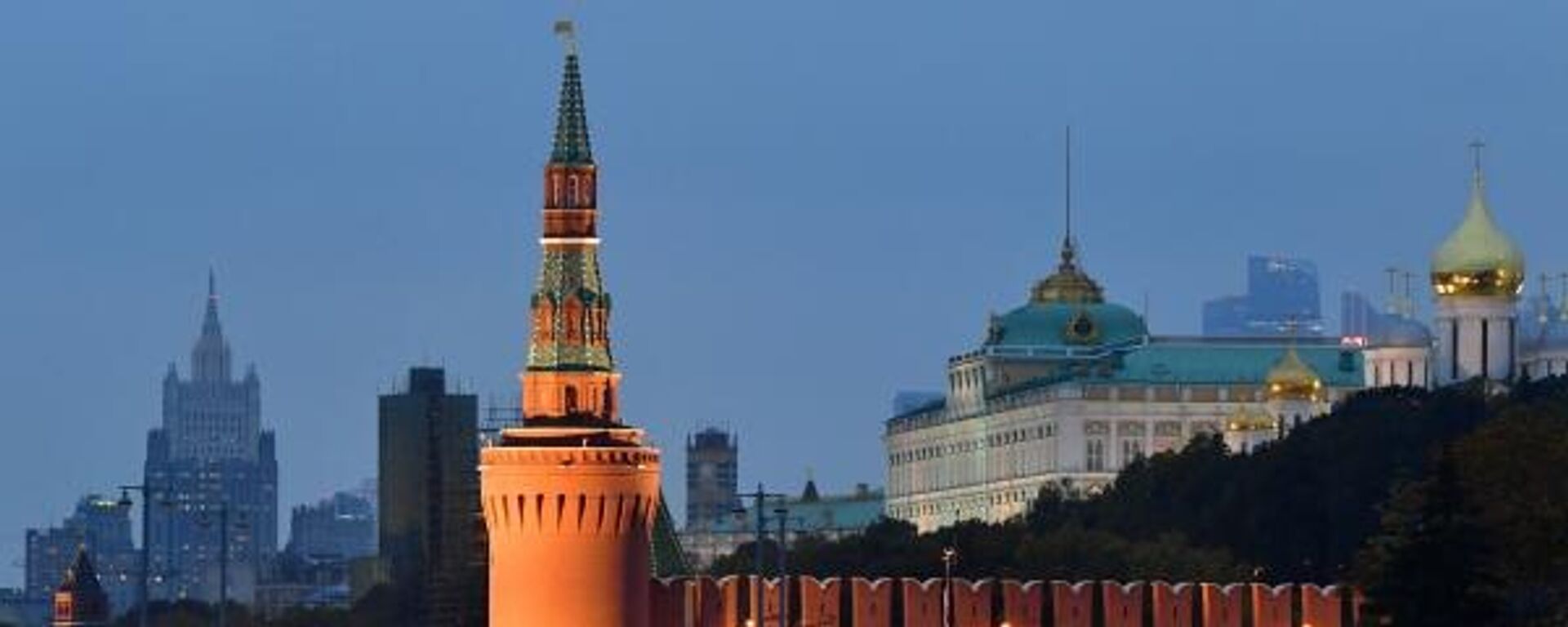 Veículos passam pelas muralhas e torres do Kremlin, com a sede do Ministério das Relações Exteriores da Rússia vista ao fundo, em Moscou - Sputnik Brasil, 1920, 29.09.2023