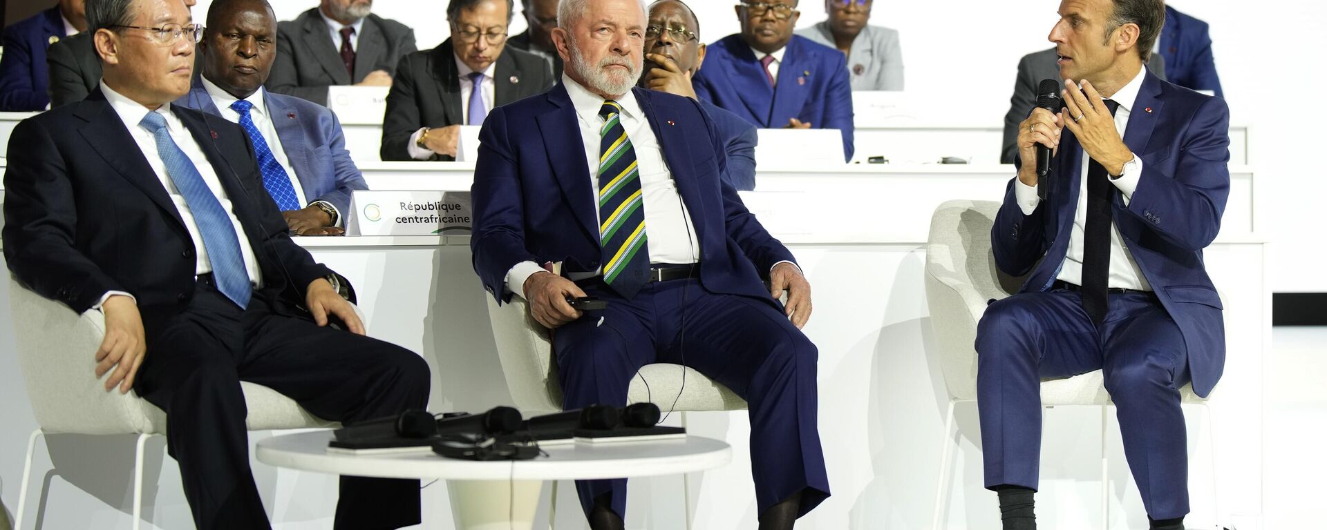 O presidente francês Emmanuel Macron, à direita, fala enquanto o presidente brasileiro Luiz Inácio Lula da Silva, ao centro, e o primeiro-ministro da China, Li Qiang, ouvem durante a sessão de encerramento da Cúpula do Novo Pacto Financeiro Global, 23 de junho de 2023 - Sputnik Brasil, 1920, 10.04.2025