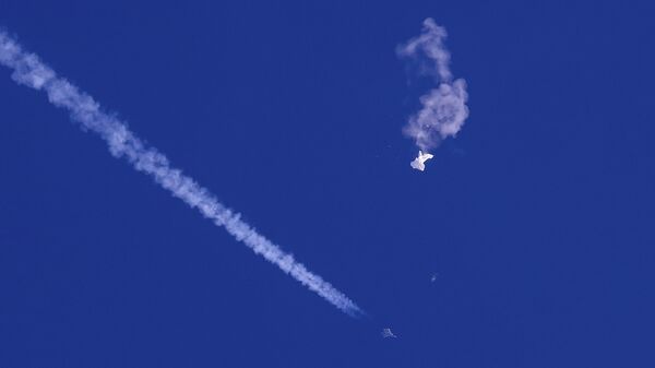 Caça voa sobre os restos de um grande balão depois que ele foi abatido perto de Myrtle Beach, sobre o oceano Atlântico, na costa da Carolina do Sul, EUA, 4 de fevereiro de 2023 - Sputnik Brasil