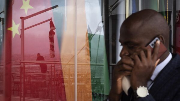 Um homem fala em um telefone celular enquanto passa por um reflexo em uma janela de outro homem olhando para o mar em frente às bandeiras nacionais dos BRICS (China, Índia, Rússia, África do Sul, Brasil) países durante a Reunião de Ministros das Relações Exteriores do BRICS na Cidade do Cabo, em 02 de junho de 2023 - Sputnik Brasil