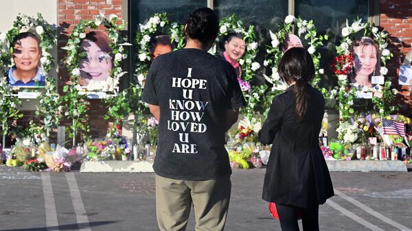 Pessoas prestam respeito para as vítimas de um tiroteio em massa em um memorial improvisado em frente ao Star Ballroom Dance Studio em Monterey Park, Califórnia, EUA, 26 de janeiro de 2023 - Sputnik Brasil