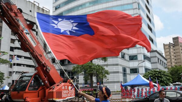 Apoiador do Kuomintang, principal partido de oposição, agita bandeira taiwanesa durante manifestação junto da sede do partido, em Taipé, Taiwan, 17 de maio de 2023 - Sputnik Brasil