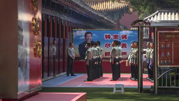Soldados do Exército de Libertação do Povo Chinês (PLA) ao lado de uma faixa representando o presidente chinês Xi Jinping perto da Cidade Proibida, no primeiro dia do Congresso Nacional do Povo da China (NPC) em Pequim, 22 de maio de 2020 - Sputnik Brasil