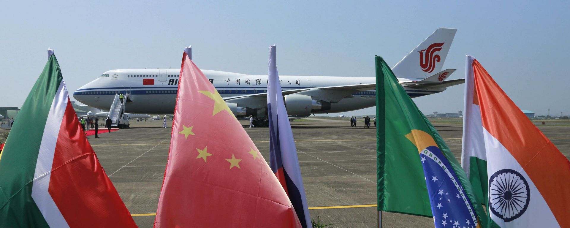 Bandeiras dos cinco países que compõem o BRICS tremulam na frente de uma aeronave da Air China na qual o presidente chinês Xi Jinping chegou para participar da cúpula do BRICS em Goa, Índia, 15 de outubro de 2016 - Sputnik Brasil, 1920, 10.09.2026
