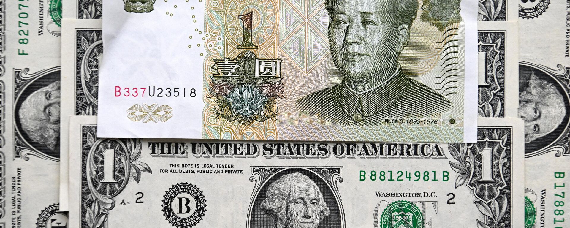 Esta fotografia tirada em 9 de fevereiro de 2023 mostra uma nota de yuan chinês e notas de dólar americano em Moscou - Sputnik Brasil, 1920, 01.08.2023