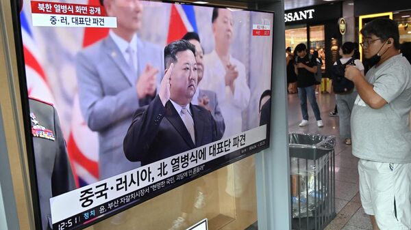 Homem assiste a tela de televisão mostrando noticiário com a presença de Kim Jong-Un, líder norte-coreano, participando de desfile militar realizado em Pyongyang, Coreia do Norte, em uma estação ferroviária em Seul, Coreia do Sul, 28 de julho de 2023 - Sputnik Brasil