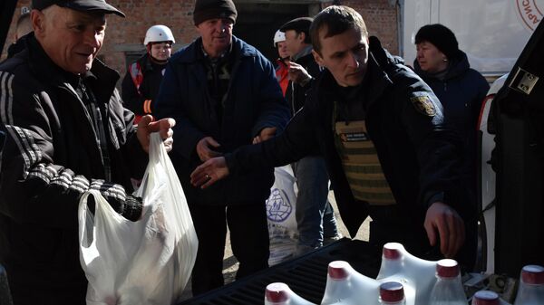Pessoas recebem pão e ajuda humanitária em ponto de distribuição na cidade de Orekhovo, Ucrânia, 6 de março de 2023 - Sputnik Brasil