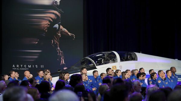 Candidatos a astronautas vestidos com trajes de voo azuis se reúnem junto de jato T-38 próximo ao palco durante o anúncio dos quatro membros da tripulação da missão lunar Artemis II em Houston, Texas, EUA, 3 de abril de 2023 - Sputnik Brasil