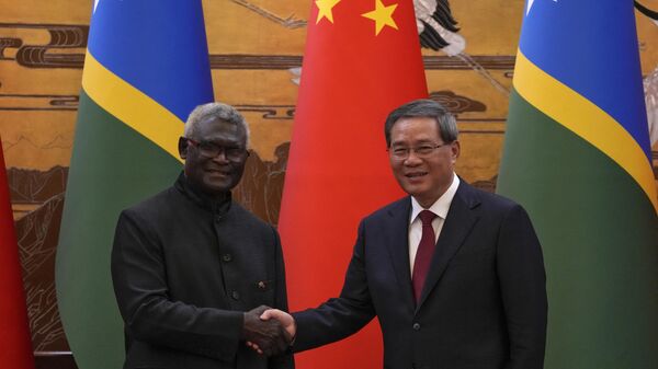 O primeiro-ministro da China, Li Qiang (D), aperta a mão do primeiro-ministro das Ilhas Salomão, Manasseh Sogavare, depois que ambos testemunharam a assinatura de um acordo entre os dois países no Grande Salão do Povo em Pequim, 10 de julho de 2023 - Sputnik Brasil
