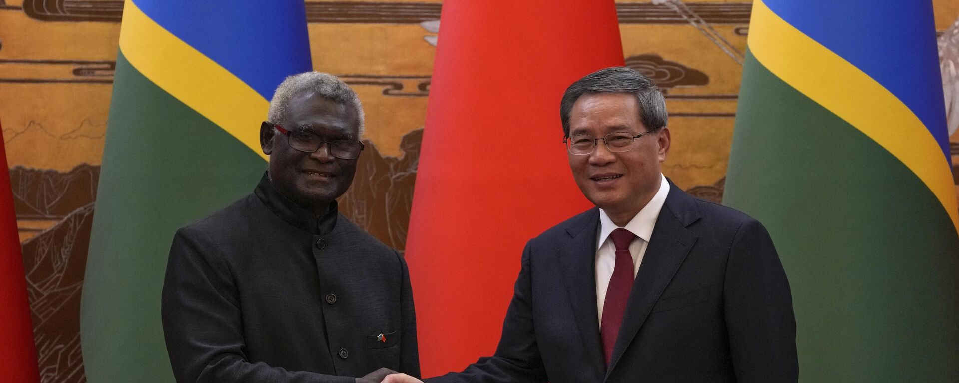 O primeiro-ministro da China, Li Qiang (D), aperta a mão do primeiro-ministro das Ilhas Salomão, Manasseh Sogavare, depois que ambos testemunharam a assinatura de um acordo entre os dois países no Grande Salão do Povo em Pequim, 10 de julho de 2023 - Sputnik Brasil, 1920, 27.09.2023